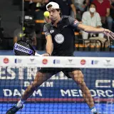 Giocatore di padel in azione, con un perfetto **split step** per colpire la palla.