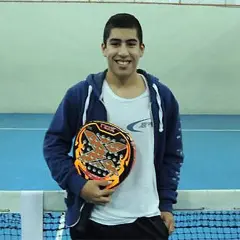 Federico Chingotto sorride con la sua racchetta da padel, pronto per la partita.