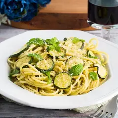 Un piatto di spaghetti con zucchine e menta fresca, un'esplosione di sapori mediterranei. Perfetto per un pranzo leggero e gustoso, questo piatto di pasta e zucchine alla siciliana è un vero piacere per il palato.