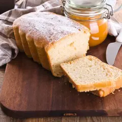 Plumcake senza uova spolverato di zucchero a velo, pronto da gustare con marmellata.