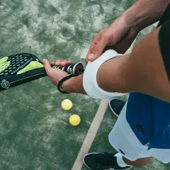 Un giocatore si prepara per una partita di padel negli Stati Uniti, impugnando la racchetta e con le palline a portata di mano.