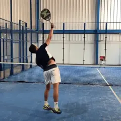 Giocatore di padel in azione, pronto a colpire la palla. La sua concentrazione è alta per fare punti padel.