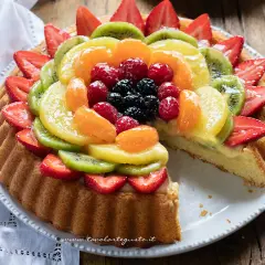 Una crostata morbida alla frutta, con fragole, kiwi, mandarini e frutti di bosco, su una base di crema pasticcera.