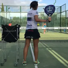 Allenamento intensivo per il corso istruttore padel. Una giocatrice si prepara a colpire la palla su un campo da padel.