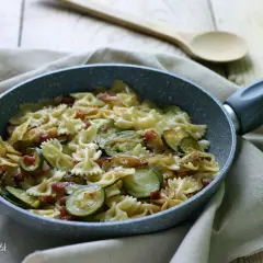 Farfalle con zucchine e pancetta croccante, un piatto semplice e gustoso pronto in padella.