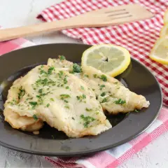 Deliziosa platessa alla mugnaia, dorata e profumata, guarnita con prezzemolo fresco e spicchi di limone.