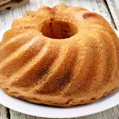 Ciambellone senza uova dorato e soffice, con la sua forma a ciambella, pronto per essere gustato.