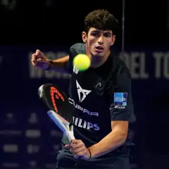 Giovane giocatore di padel in azione, colpisce la palla con la racchetta.