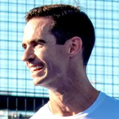 Un uomo sorride con entusiasmo, pronto per una partita di padel.