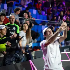 Luigi Carraro, giocatore di tennis, scatta un selfie con i tifosi entusiasti sugli spalti.
