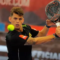 Giocatore di padel con racchetta in mano, pronto a colpire la palla. La sua maglia nera ha un logo che ricorda un cobra rosso.