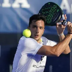 Un giocatore di padel, forse Alba Galán, colpisce la palla con una racchetta Adidas.
