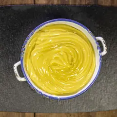 Crema pasticcera vegana, liscia e lucida, in una ciotola con bordo decorato, pronta per farcire dolci.