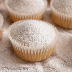 Muffin senza uova, soffici e spolverati di zucchero a velo, pronti per essere gustati.