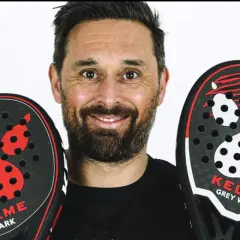 Mati Diaz sorride con due racchette da padel Kelme, una "Shark" e una "Grey Wolf", entrambe con un design a zampa.