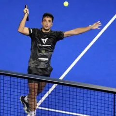Giocatore di padel in azione, colpisce la palla con un lob perfetto.