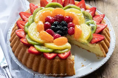 Una crostata morbida alla frutta, con fragole, kiwi, mandarini e frutti di bosco, su una base di crema pasticcera.