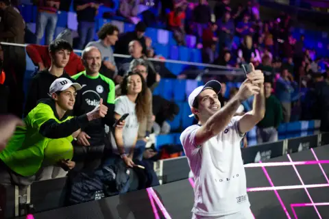 Luigi Carraro, giocatore di tennis, scatta un selfie con i tifosi entusiasti sugli spalti.