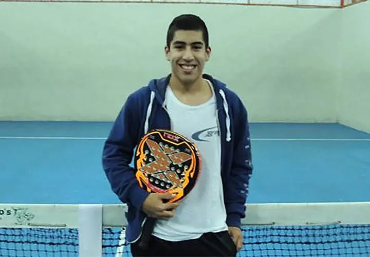 Federico Chingotto sorride con la sua racchetta da padel, pronto per la partita.