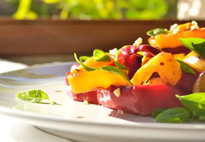 Insalata colorata con peperoni arrostiti, pomodori e basilico fresco. Un'idea gustosa per le tue ricette con peperoni.