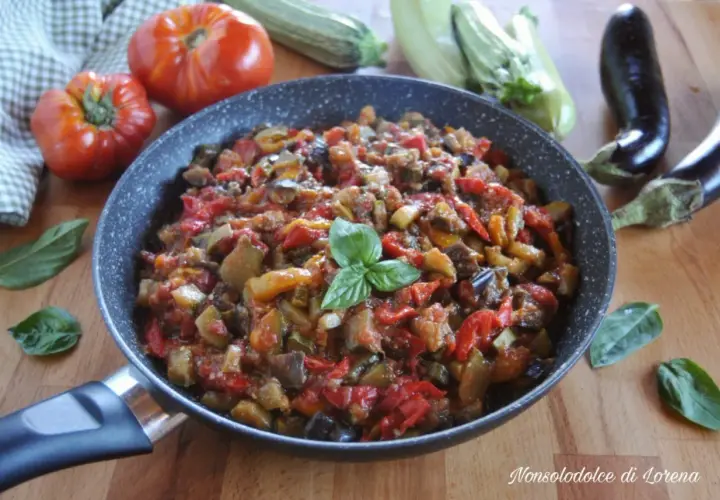 Ratatouille ricetta in padella, con melanzane, zucchine, pomodori e peperoni, guarnito con basilico fresco.