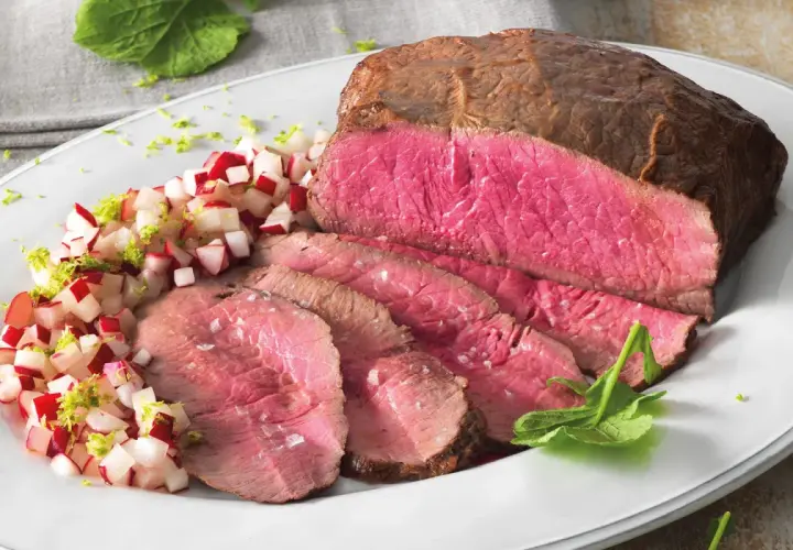 Roast beef ricetta in pentola: succulento e rosato, servito con un contorno fresco di ravanelli e scorza di lime.