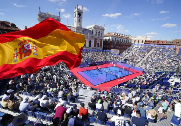 Bandiera spagnola sventola su un campo da padel gremito di spettatori. Atmosfera vibrante per il padel in Spagna.