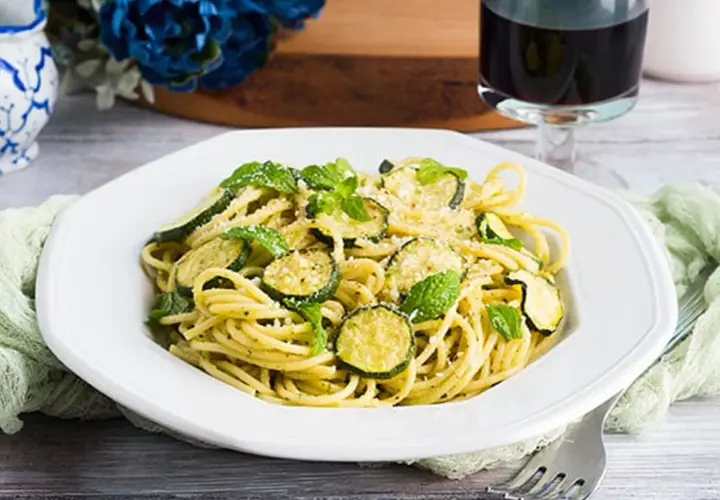 Un piatto di spaghetti con zucchine e menta fresca, un'esplosione di sapori mediterranei. Perfetto per un pranzo leggero e gustoso, questo piatto di pasta e zucchine alla siciliana è un vero piacere per il palato.