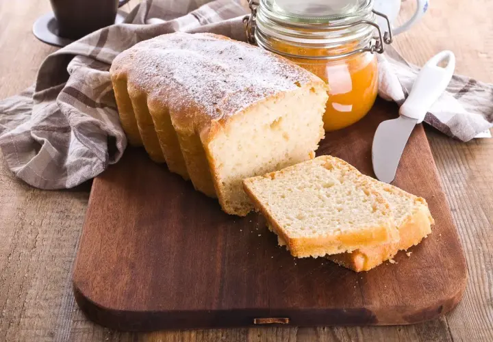 Plumcake senza uova spolverato di zucchero a velo, pronto da gustare con marmellata.