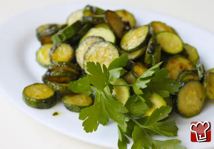 Fette di zucchine saltate in padella, condite con olio e prezzemolo fresco, un classico piatto di zucchine alla poverella.