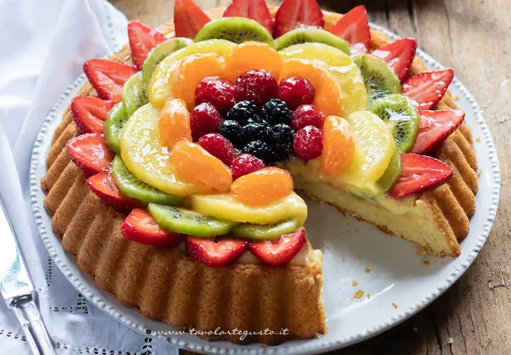Una crostata morbida alla frutta, con fragole, kiwi, mandarini e frutti di bosco, su una base di crema pasticcera.