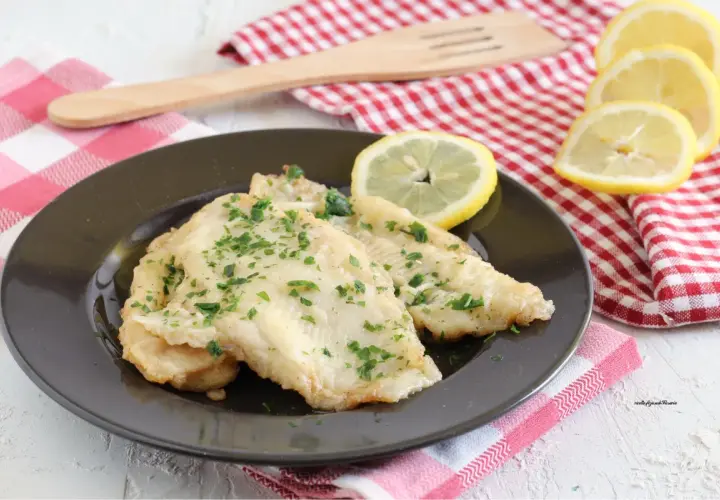 Deliziosa platessa alla mugnaia, dorata e profumata, guarnita con prezzemolo fresco e spicchi di limone.