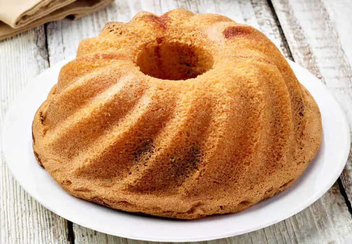 Ciambellone senza uova dorato e soffice, con la sua forma a ciambella, pronto per essere gustato.