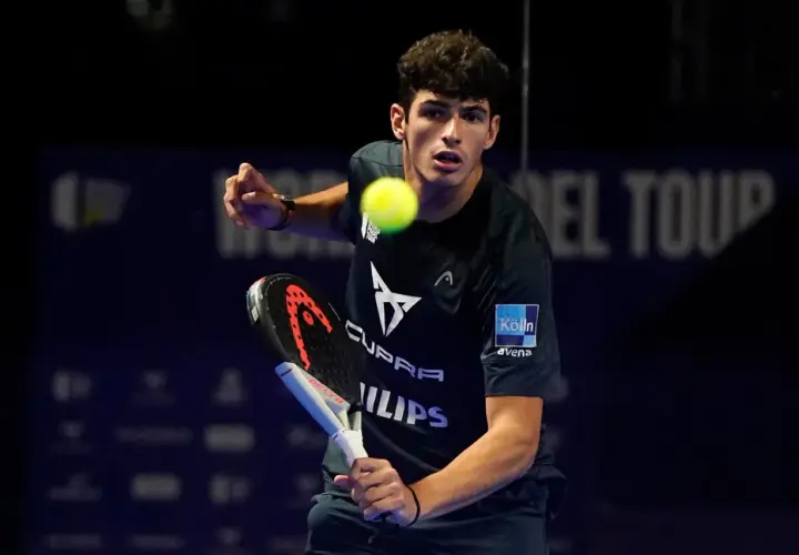 Giovane giocatore di padel in azione, colpisce la palla con la racchetta.