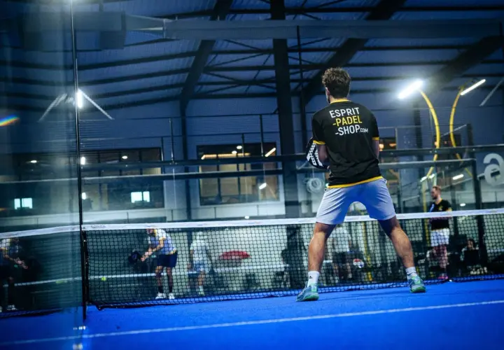 Giocatore di padel in azione, con la scritta "Esprit Padel Shop" sulla maglia. La partita è intensa, ma lui non è una dormilona al padel.