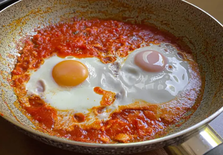 Uova in purgatorio, due uova cotte in un sugo di pomodoro piccante, un piatto saporito e confortante.