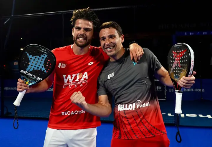 Lucas Campagnolo e il suo compagno festeggiano una vittoria nel padel, sorridenti con le racchette in mano.