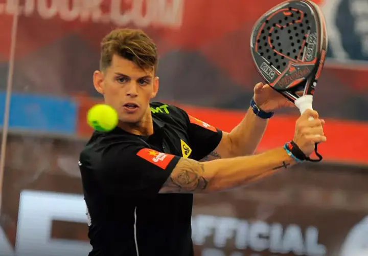 Giocatore di padel con racchetta in mano, pronto a colpire la palla. La sua maglia nera ha un logo che ricorda un cobra rosso.