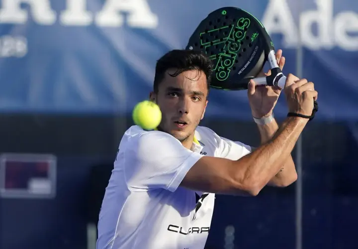 Un giocatore di padel, forse Alba Galán, colpisce la palla con una racchetta Adidas.