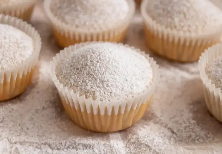 Muffin senza uova, soffici e spolverati di zucchero a velo, pronti per essere gustati.