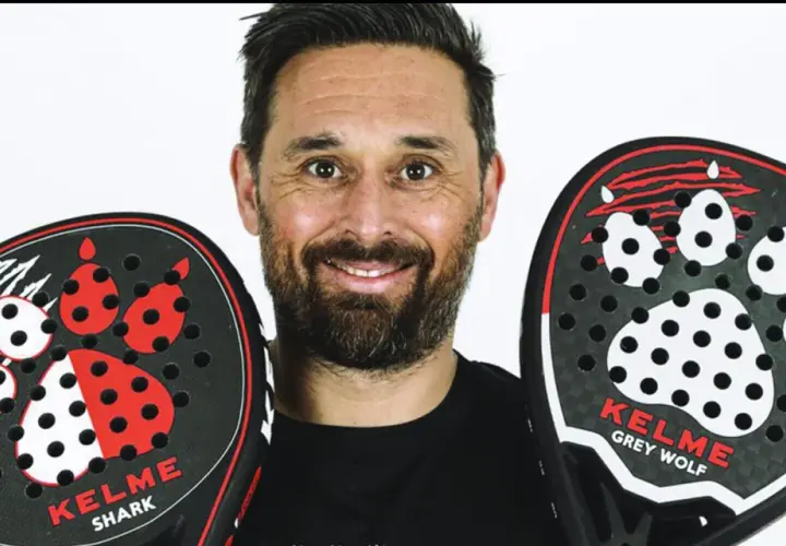 Mati Diaz sorride con due racchette da padel Kelme, una "Shark" e una "Grey Wolf", entrambe con un design a zampa.
