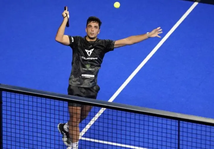 Giocatore di padel in azione, colpisce la palla con un lob perfetto.