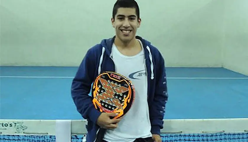 Federico Chingotto sorride con la sua racchetta da padel, pronto per la partita.