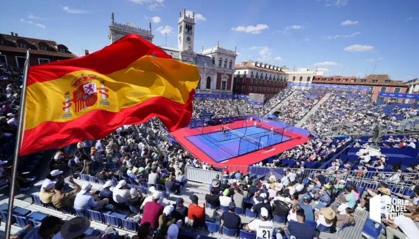 Bandiera spagnola sventola su un campo da padel gremito di spettatori. Atmosfera vibrante per il padel in Spagna.