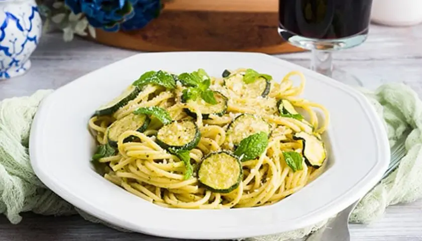 Un piatto di spaghetti con zucchine e menta fresca, un'esplosione di sapori mediterranei. Perfetto per un pranzo leggero e gustoso, questo piatto di pasta e zucchine alla siciliana è un vero piacere per il palato.