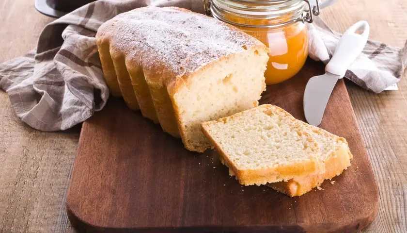 Plumcake senza uova spolverato di zucchero a velo, pronto da gustare con marmellata.
