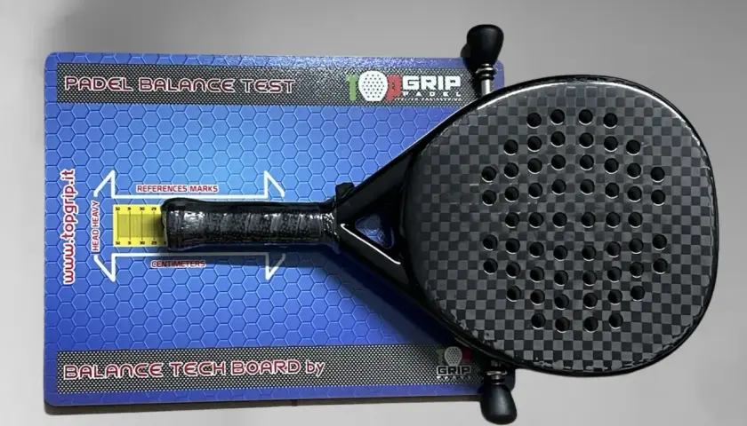 Racchetta da padel su tavola per test di bilanciamento. Misura il bilanciamento della racchetta per un gioco ottimale.