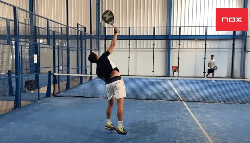 Giocatore di padel in azione, pronto a colpire la palla. La sua concentrazione è alta per fare punti padel.