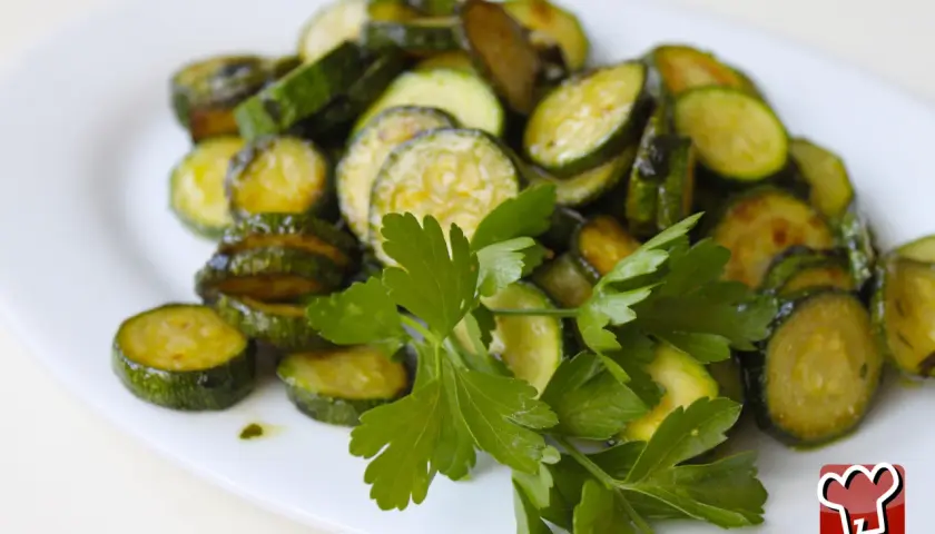 Fette di zucchine saltate in padella, condite con olio e prezzemolo fresco, un classico piatto di zucchine alla poverella.