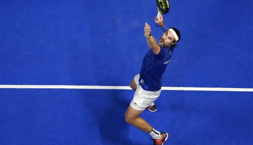 Giocatore di padel in azione, pronto a eseguire uno smash x3. La palla è in aria, la racchetta alza.